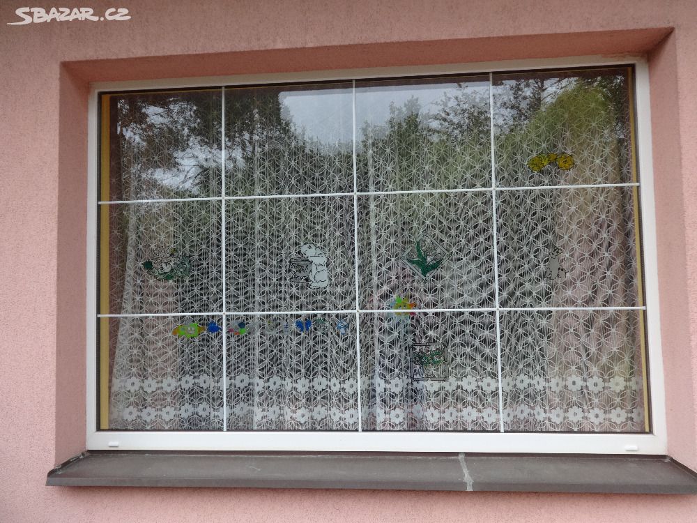 pevné plastové okno s bílou mřížkou