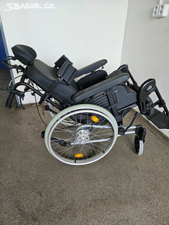 Polohovací invalidní vozík.