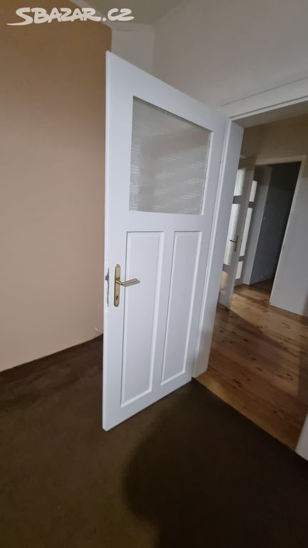 Bílé interiérové dveře s dřevěnou obložkou